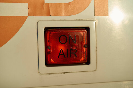 Red ON AIR sign, illuminated sign on equipment indicating live broadcast in progress.