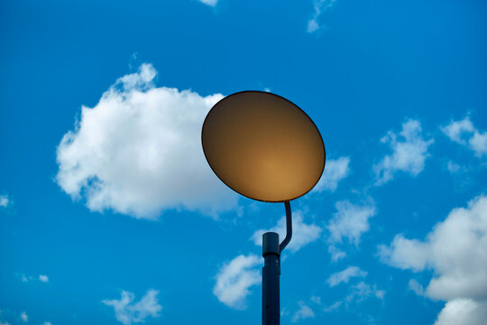 Street lamp against a blue sky with fluffy white clouds, Berlin, Germany