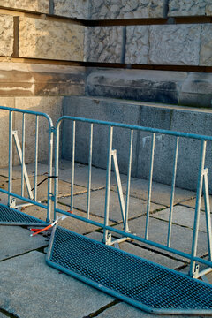 Sunlight casts shadows on metal barriers in front of a marble wall, Berlin, Germany