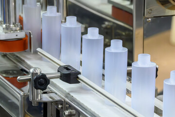 The  empty cosmetic  bottles on the conveyor belt for filling process.