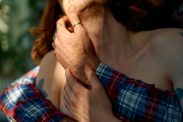 Close-up of a gay couple embracing, with a focus on their hands gently holding each other.