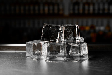 Close-up side view of several large ice cubes stacked in two layers lying