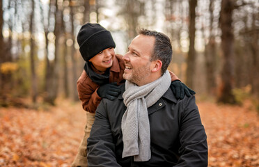 Joyful dad and his child boy. daddy and child have fun, laugh and enjoy nature outdoors at autumn...