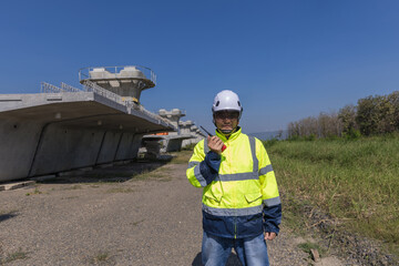 Asian engineer working at site of a large building project. Engineering, construction site and team outdoor for Transportation construction project.