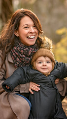 Joyful mother and his little baby. mother and child have fun, laugh and enjoy nature outdoors at autumn park.