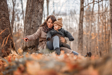 Joyful mother and his little baby. mother and child have fun, laugh and enjoy nature outdoors at autumn park.