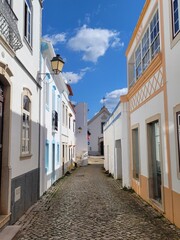 Cobblestone street with painted houses in Alte, Portugal