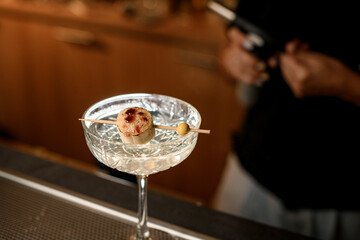 Focus on a piece of banana with melted sugar strung on a wooden skewer resting