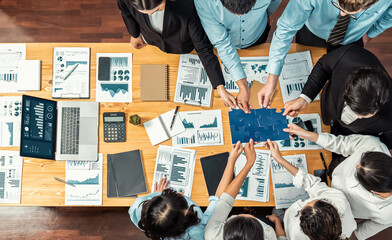 Multiethnic business people holding jigsaw pieces and merge them together as effective solution...