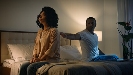 Sad offended African American woman wife feeling bad about breakup problem relationship trouble with erectile dysfunction man husband touch female calming lady walk away couple family on bed at night