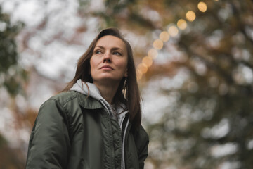 Close up of  upset thoughtful young female feel lonely pondering, walking in autumn park 