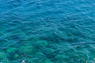 The shimmering turquoise waves of a tranquil ocean on a sunny day.