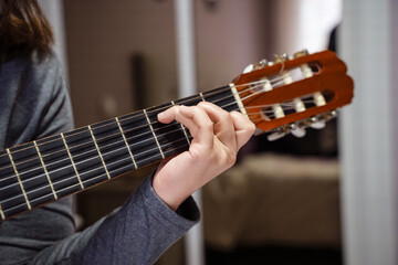 Musician playing acoustic guitar at home