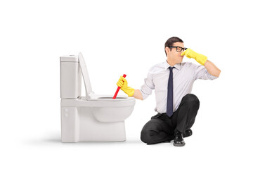 Young man cleaning a smelly toilet