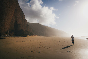 海岸の光の中を歩く人