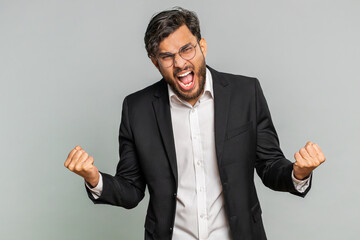 Irritated angry Indian businessman screams from stress tension problems feels horror hopelessness fear surprise shock expresses rage nervous, quarrel. Arabian man isolated on gray studio background