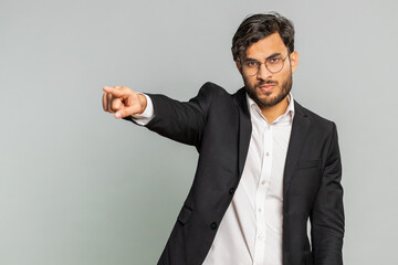 Get out of here. You are fired. Irritated Indian businessman pointing finger away asking to leave him alone, strict boss firing, conflict, quarrel. Male Arabian man guy isolated on gray background