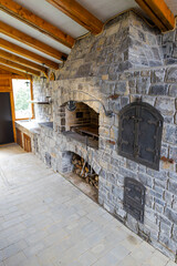 Stone barbecue firewood, open brick oven for cooking kebabs and other dishes on fire indoors in...