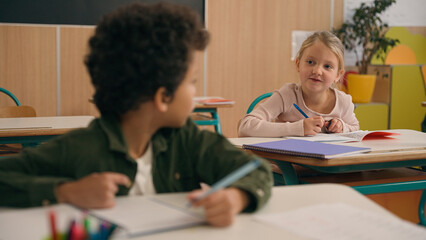 Multiracial diverse little classmates multiethnic students pupils two children kids Caucasian girl...