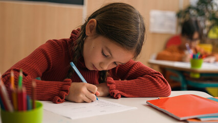 Caucasian clever happy little girl school test study task exam writing notes class lesson learn...