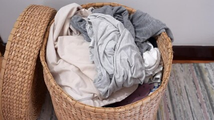 Clothing items being thrown into a laundry basket highlighting the motion and casual nature of household chores, perfect for themes of cleanliness, organization, and daily routines