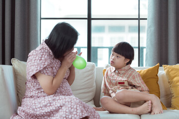 A special child and his mom having fun and relaxing on a holiday together in the living room of the house