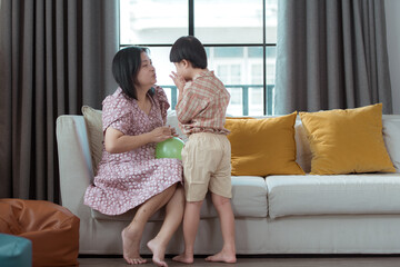 A special child and his mom having fun and relaxing on a holiday together in the living room of the house