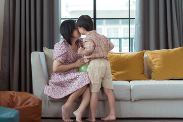 A special child and his mom having fun and relaxing on a holiday together in the living room of the house