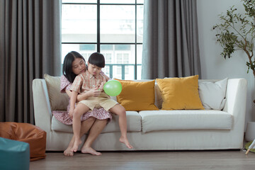 A special child and his mom having fun and relaxing on a holiday together in the living room of the house