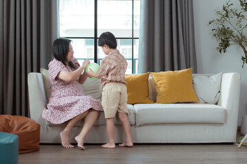 A special child and his mom having fun and relaxing on a holiday together in the living room of the house