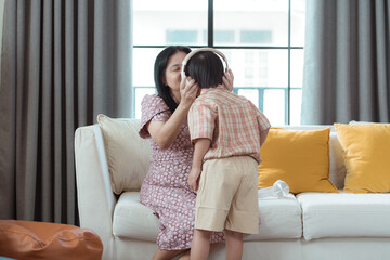 A special child and his mom listening to music together in the living room of the house