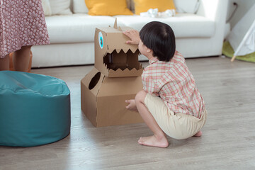 A special child with his favorite dinosaur figure, having fun in the living room of the house