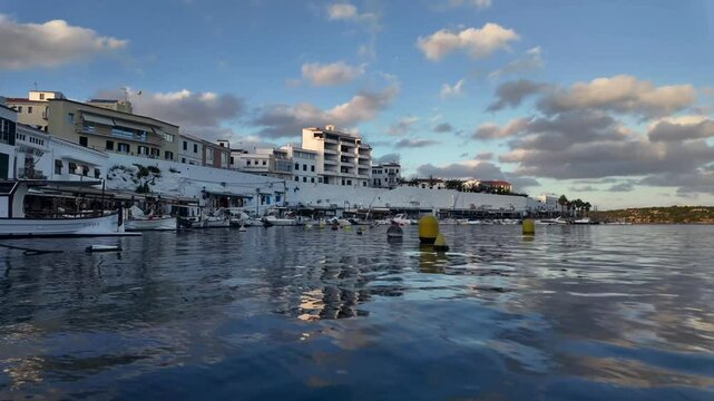 Timelapse of Es Castells seafaring village in Menorca Island in Spain. Afternoon warm light reflected on the Sea. 4K