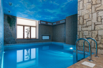 Swimming pool in a private house with magnificent decor of walls and ceiling.