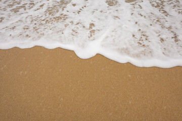 Background close-up of ocean waves rolling on the sand on the beach, with a sand texture. Sandy beach by the sea. A deserted area. Realistic seamless illustration with fine details.