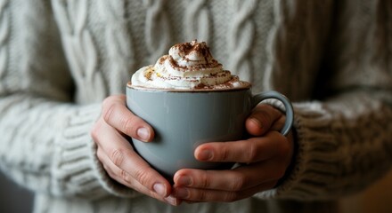 Cozy person holding mug of hot cocoa with whipped cream