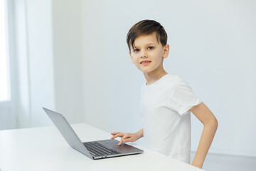 Boy Learning Online With A Laptop At A Table At Home