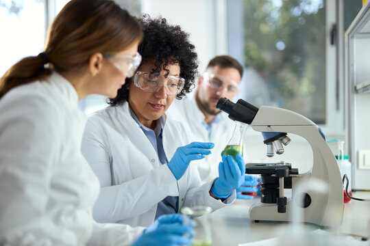 Group of chemists talking while working on antiviral drug in laboratory. 