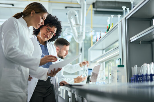 Medical experts talking while working on medical research in laboratory.