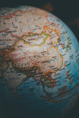 China on the world globe - a close up shot of the country of China and the continent of Asia as seen on a vintage globe \ map