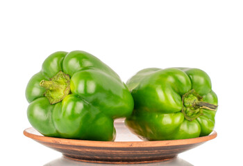 Sweet green capsicum on a clay plate, macro, isolated on white background.