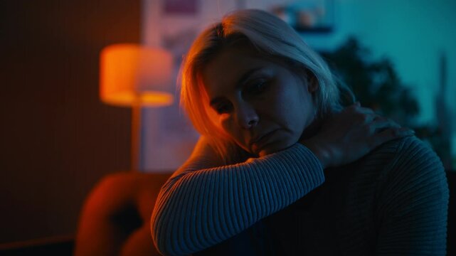 Unhappy middle-aged woman sitting alone on couch, difficult period of life