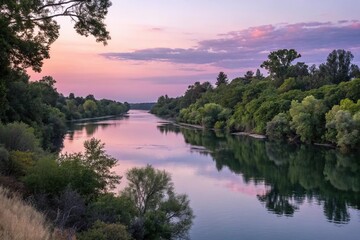 Fototapeta premium Lush greenery and tranquil water of the Sacramento River at dusk, atmospheric, golden hour, scenic, dusk