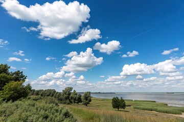 A serene landscape with a clear blue sky and white clouds drifting lazily across the horizon, sunny day, fluffy clouds, nature scene, landscape