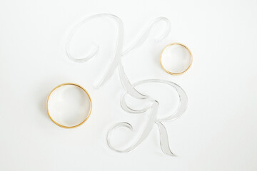 Wedding rings on a white background. Initials K and R for the couple. Love symbol. Wedding background.