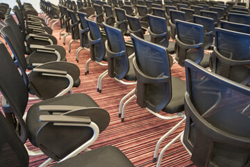 Fototapeta premium Rows of empty conference chairs on patterned carpet in modern meeting room.