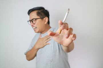 Unhealthy young Asian men got chest pain when smoking isolated on white background.