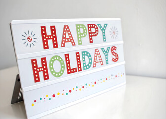 A close up of a happy holidays sign on a table