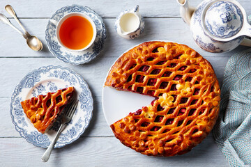 Berry sweet pie with cup of tea. Grey background. Close up. Top view.