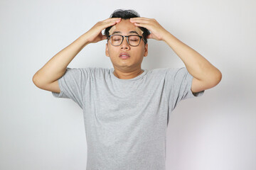 Dizzy asian young men, men headache or migraine pain suffering from vertigo while sitting on couch...